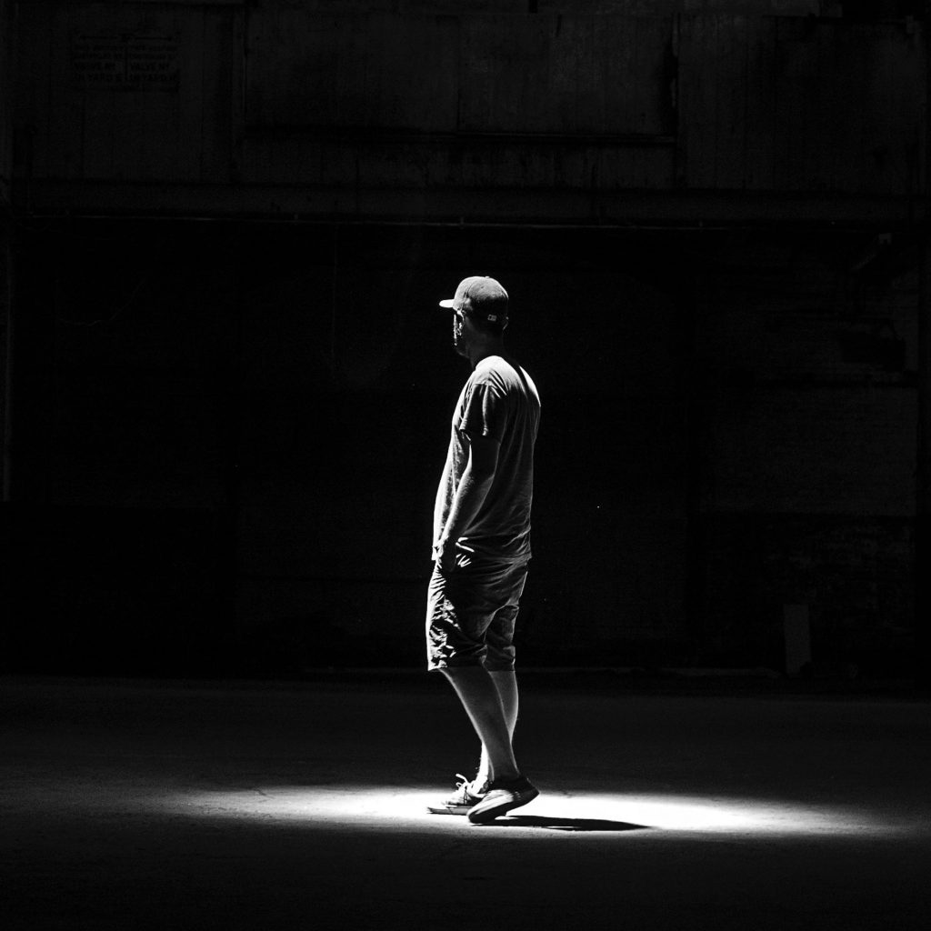 Man standing alone in spotlight.